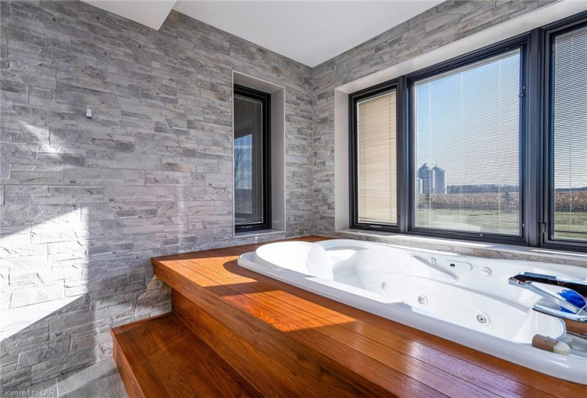 Behind beautiful rolling glass doors is the built in jacuzzi tub all on its own feeling like you are in your own spa under the stars.